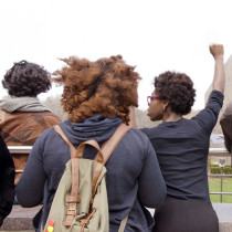 Students gather on campus; one raises fist