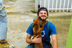 Patrick Moore '21 with a dog as he volunteers with the SUNY Stands with Puerto Rico initiative