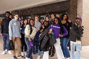Group of students led by students in purple Purchase College sweatshirt