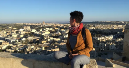 Student looks down on city below