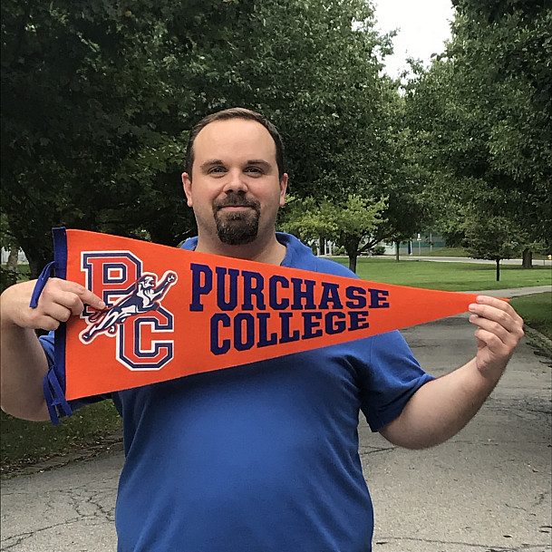 Christopher Yusko holding a pennant showing his school spirit