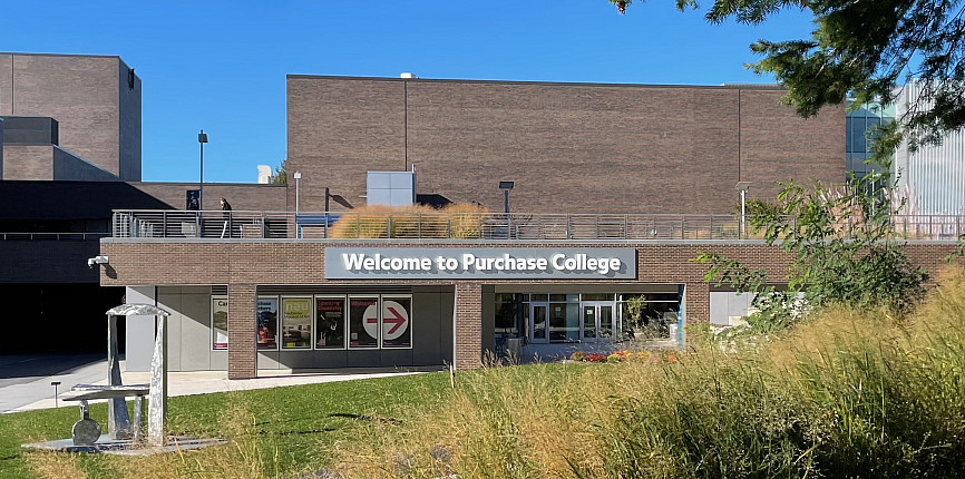 Silver + white Welcome to SUNY Purchase sign above pedestrian entrance to campus at Admissions Office in CMFT building