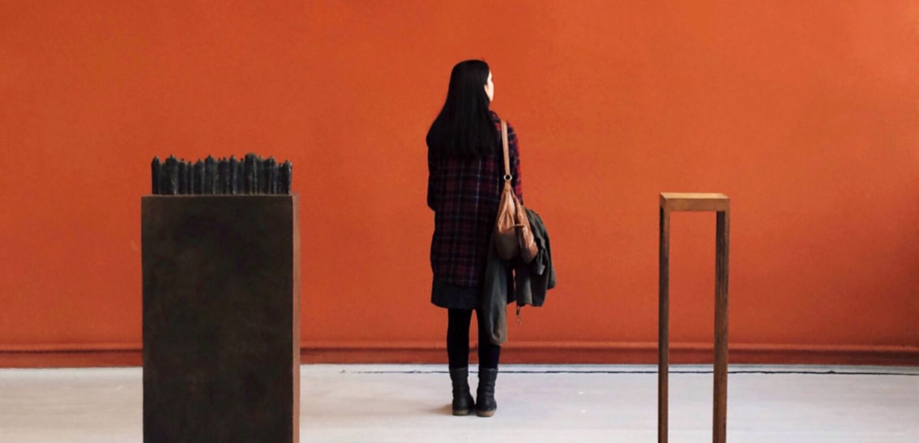 A person standing in front of an orange wall