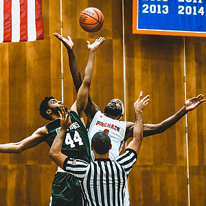 Two students playing basketball.