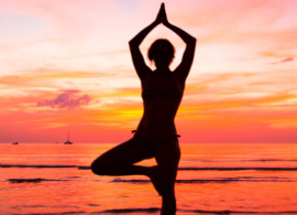 standing yoga pose in front of sunset.