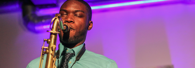 Young black man plays saxophone