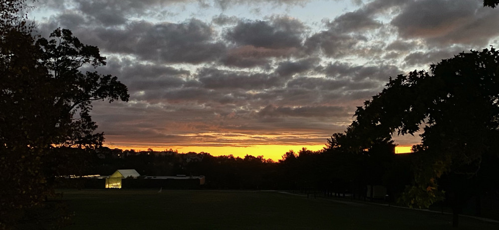 The sun rises over the Physical Education building.