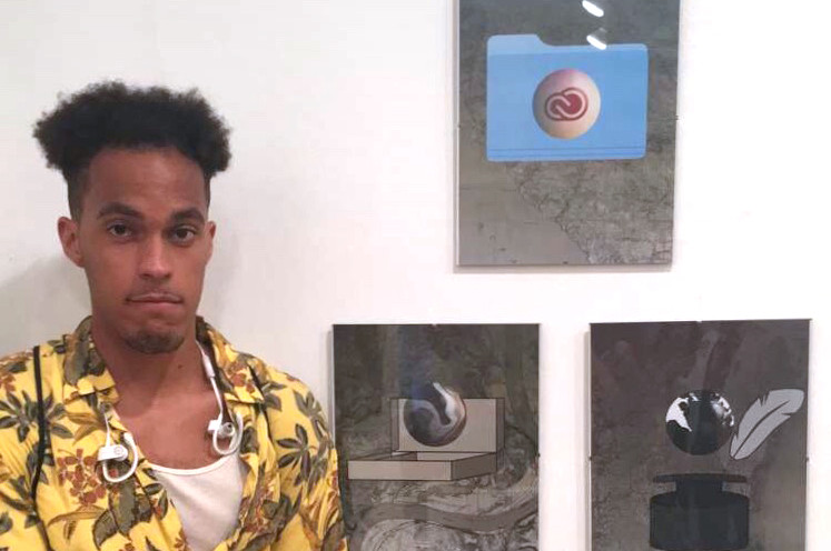 Darren Dempster '18 stands with his work in a gallery.