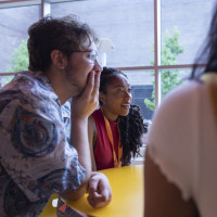 Students talk at a table.