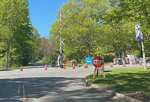 A crossroads with orange cones and a railroad crossing gate.