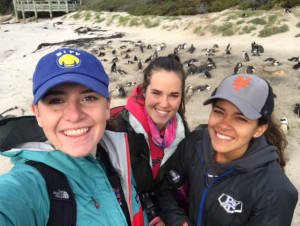 Kelly Hayes '19, Mary Adams '17, and Briana Leon '17 on the beach with penguins on Boulder Beach