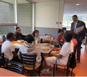 Chancellor King stands at a table chatting with EOP students.