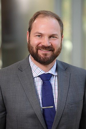 Photo of Colm McCarthy wearing a grey stud with navy tie.