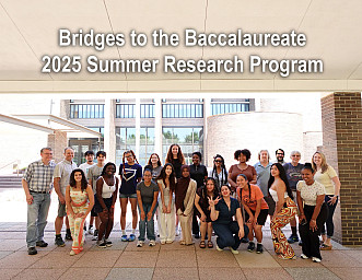 Students, faculty and staff smiling and posing in front of the brick Natural Sciences building at Purchase College.