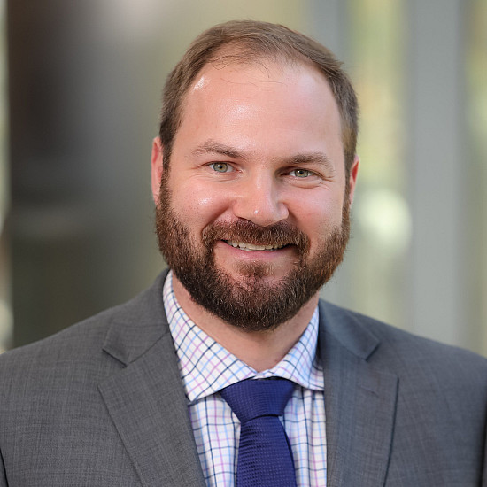 Photo of Colm McCarthy wearing a grey stud with navy tie.