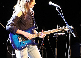 A student of the studio composition program performs on guitar and vocals.