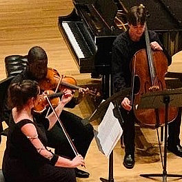 Two violinist and a cellist in performance.