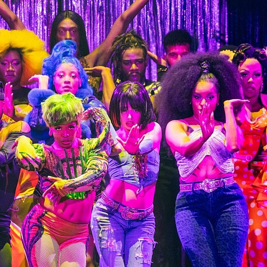 14 actors on stage dressed in neon striking vogue poses