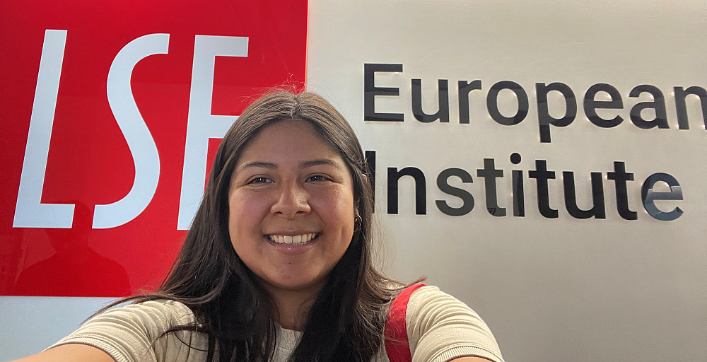 Stephanie Sanchez stands in front of a banner with London School of Economics named