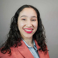 Potrait photo of Caroline Jimenez in pink blazer smiling