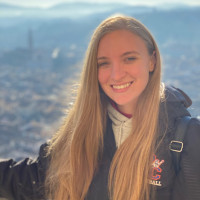 Student Kelly Agostini Smiling with a city landscape in the background