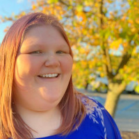 Headshot of Kelly Cashman outdoors next to yellow trees