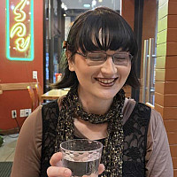Student Lilith McCarthy holding a coffee cup while smiling