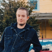 Student Dylan McKenna leaning against a car