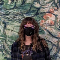 Student Emma Eager standing in front of a painting