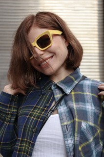 Student Hannah Olesen wearing yellow sunglasses and smiling