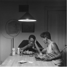 A couple at a dimly lit table eating lobster.