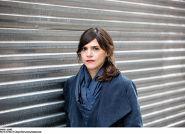 Author Valeria Luiselli standing in front of gray wall