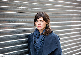 Author Valeria Luiselli standing in front of gray wall