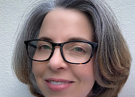 headshot of woman in glasses smiling