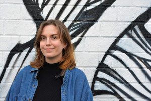 Student Emily Czerwinski standing in front of a graffitied wall