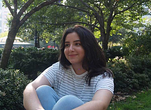 Student Lianna Lazaros sitting with arms around knees.