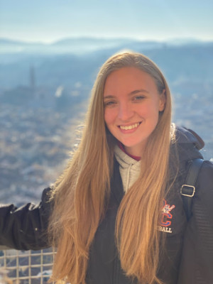 Student Kelly Agostini Smiling with a city landscape in the background