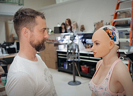 Filmmaker Jimmy Mehiel standing across from a Sex Robot prototype