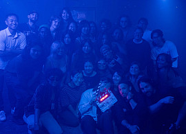 Group of UFO Short Film Lab Students together on a hazy blue lit set. Student in front holding clapperboard.