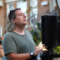 Photographer Gregory Crewdson ’85 setting up a shot with his 8x10 camera on location in Pittsfield, Massachusetts at the corner of S...