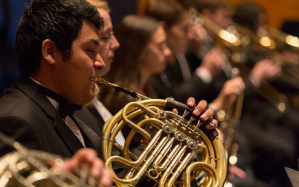 A student playing a French horn