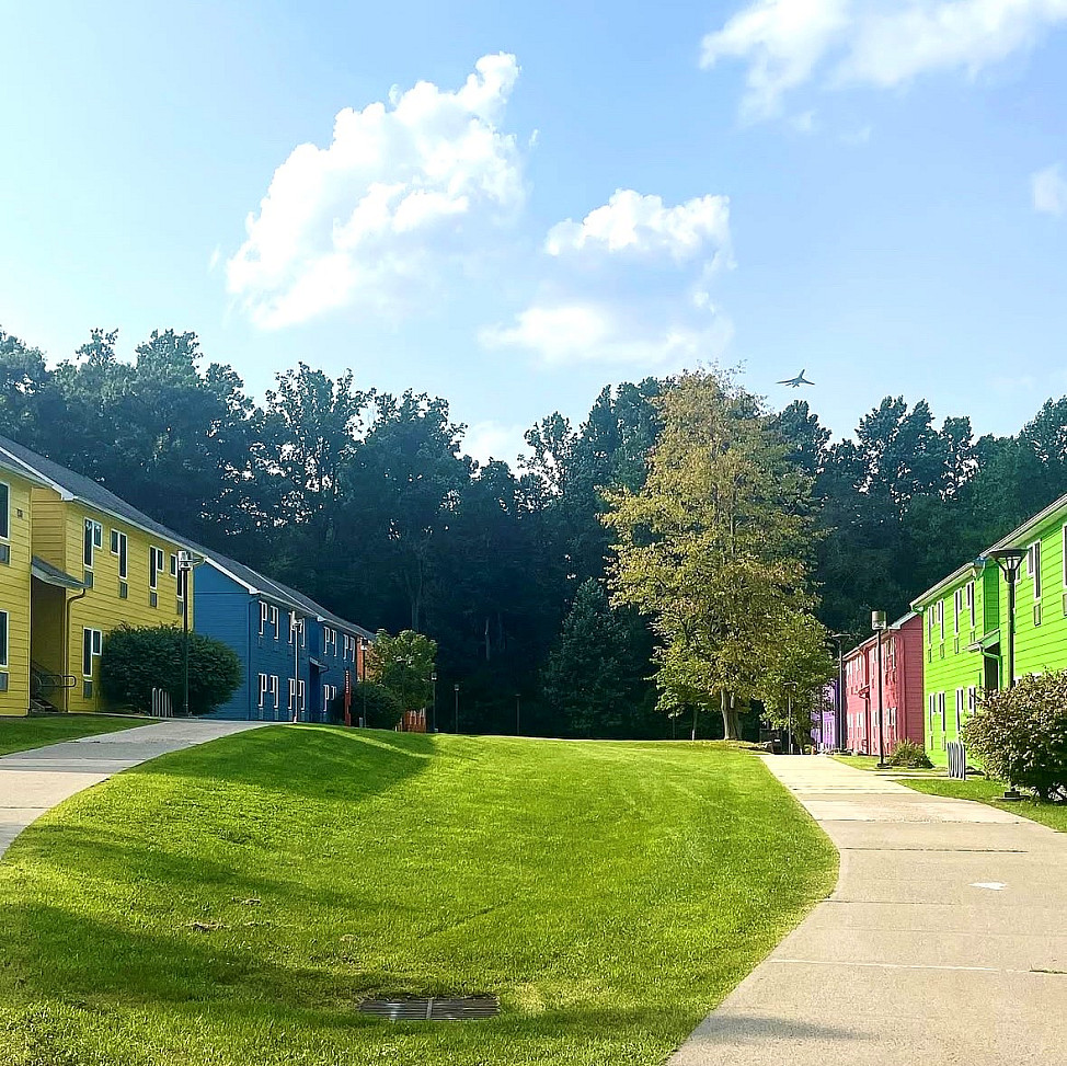 Colorful buildings on either side of a grassy lawn area. 