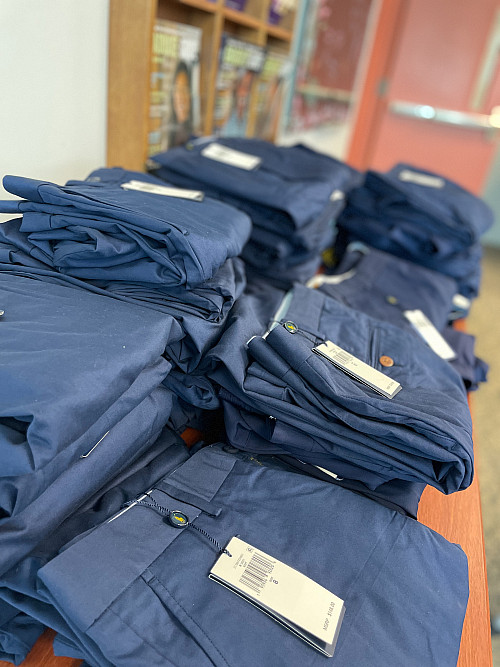 Stacks of new dark blue pants on a table