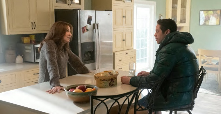 Edie Falco and Pete Davidson face each other over a kitchen counter.