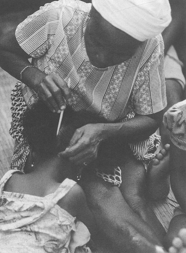 Ma Kpanna dressing hair of Simo Bolay at the entrance into Sande Bush Bandi Bolahun