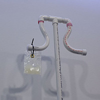 Oil (detail), 2020, PVC, electrical tape, casters, zip tie, oil, dental dam package, 2'5x 7'5