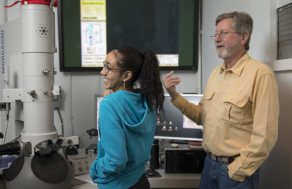 Professor Jan Factor works with a student on electron microscope