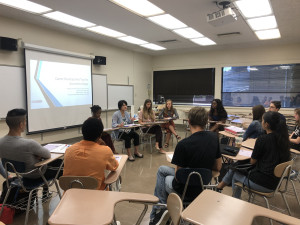 Students in the economics club sitting at desks in a classroom