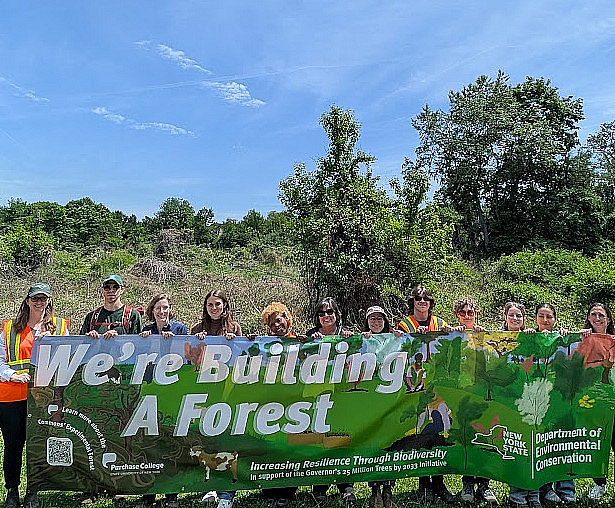 Many people holding a banner that says We're building a forest