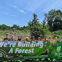 Many people holding a banner that says We're building a forest